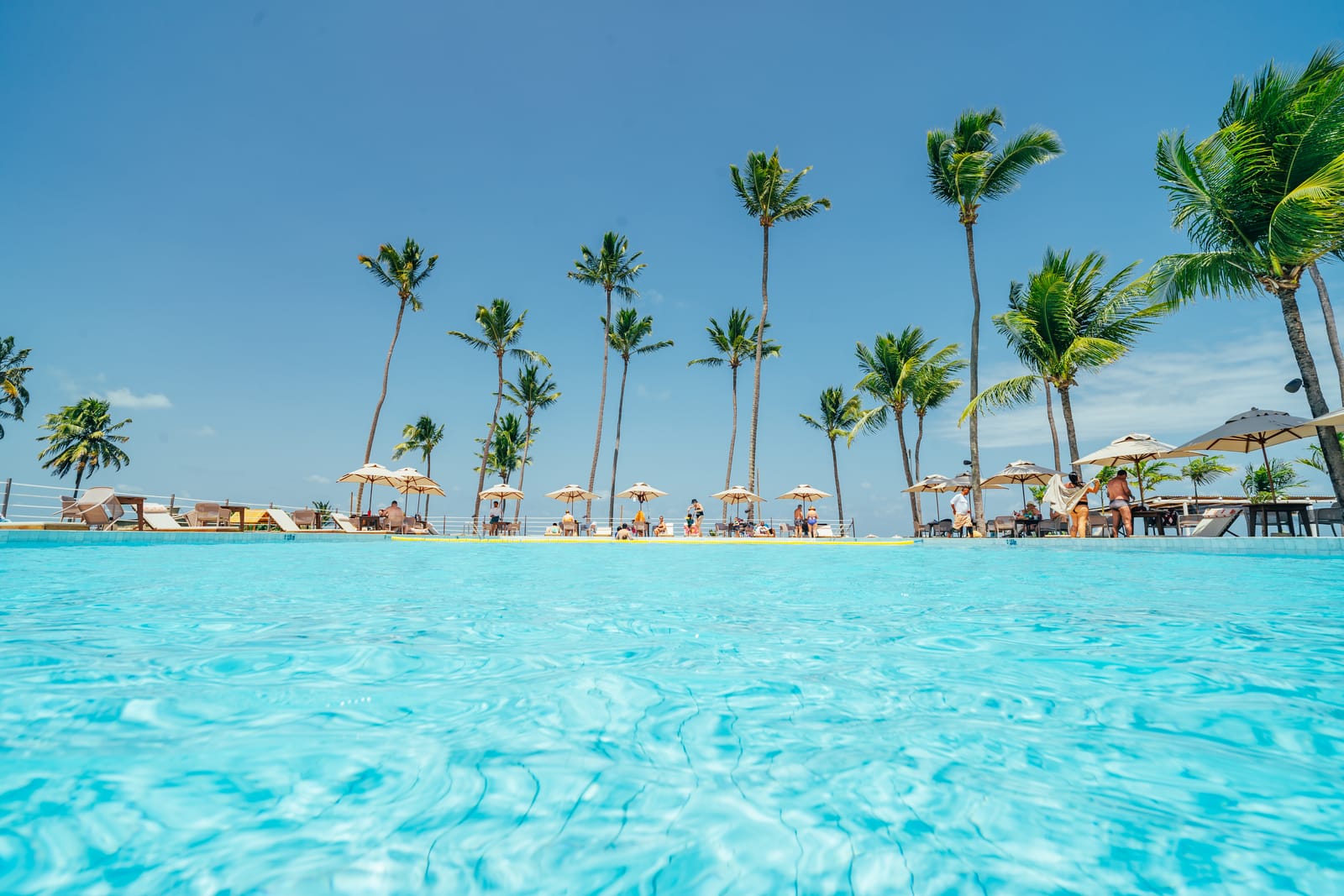 Piscina e coqueiros do Vivari Beach Club, à beira-mar em Ipioca